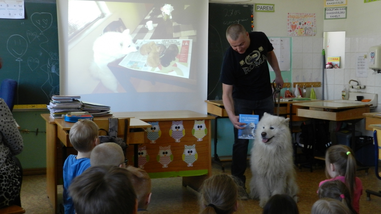  Koeraomanik oma valge koeraga laste ees esinemas.